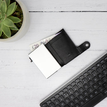 Photo of a black Raptor RFID Trifold Wallet laid on a table showing a £20 inside the card holder