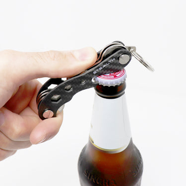 Picture of the Pocket Key Holder opening a beer on a white background