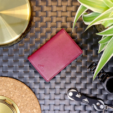 Picture of a red Avenger RFID Bifold Wallet  laid out on a decorated table surrounded by other Stealth Wallet products