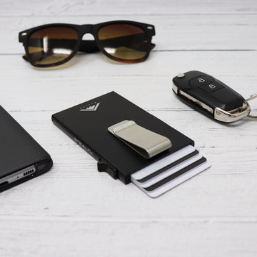 Photo of the Raptor RFID Wallet with a stainless steel money clip on a table next to a pair of car keys and sunglasses