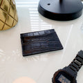 Picture of a Raider RFID Wallet on a table next to a watch and lamp