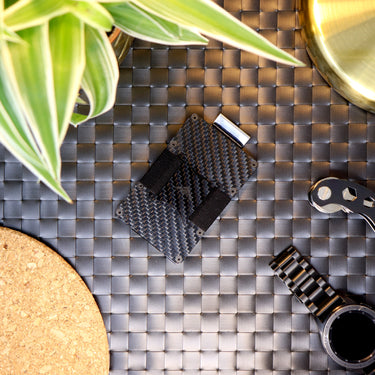 Picture of a Nighthawk RFID Card Holder laid out on a table next to a watch, plant and key organiser