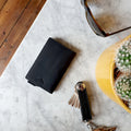 Picture of The Minimalist Genuine Leather Key Organiser laid on a table next to a wallet and sunglasses